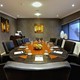 Meeting setup with oval table and writing materials water and fruit